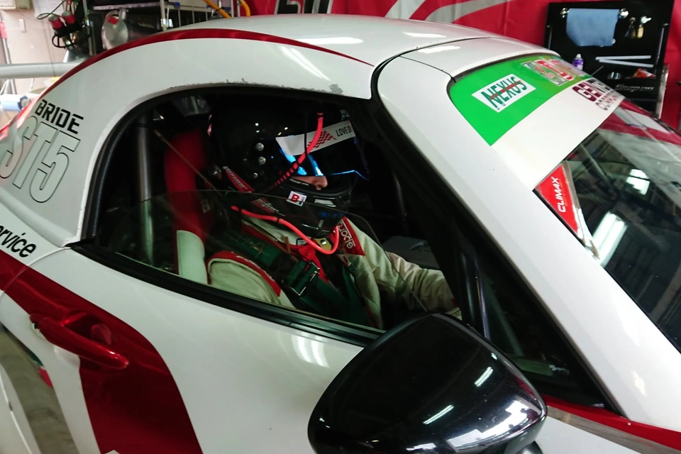 レーシングカーに乗る佐藤さんの写真